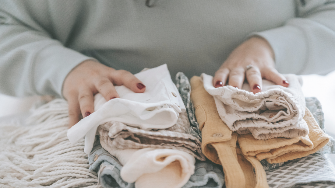 A mom neatly folding toddler clothing after properly washing, drying, and storing.